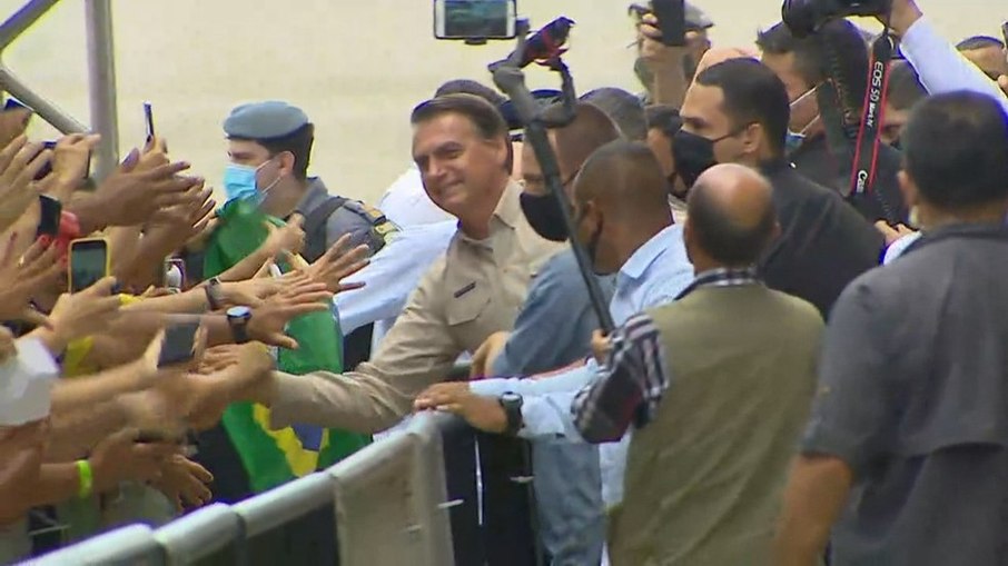 Bolsonaro causa aglomeração e segura no colo criança com arma de brinquedo
